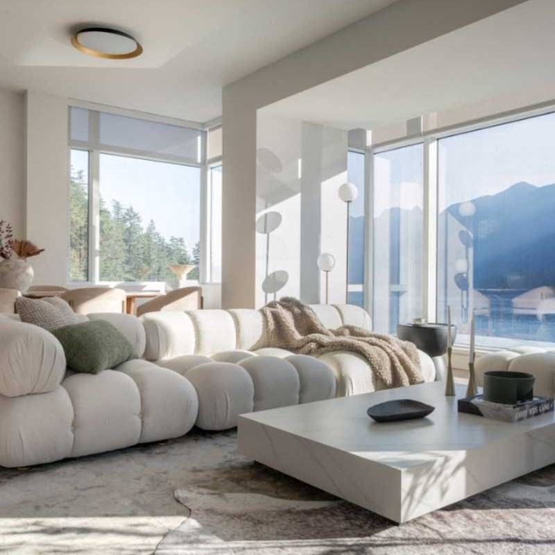 Angled View of The Belia Modular Sectional With Alesund Fabric in a Living Room Next to A Window Overlooking Lake