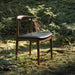 A Single Elbow Chair in Trento Jet Black and Wood Finishes in The Woods