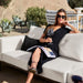 Woman Enjoying a Glass Of Wine While Sitting On The Francis Outdoor Modular Sectional Sofa In Palisades Color With Black Base