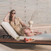 Close Up of a Woman With a Drink And Fruit Lounging On The Francis Outdoor Lounger In Palisades Color With Black Base