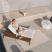 Overhead View of a Woman With a Drink And Fruit Lounging On The Francis Outdoor Lounger In Palisades Color With Black Base