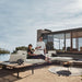 Angled View of a Couple Using The Francis Outdoor Modular Right Chaise And Sofa In Palisades Color Shot In Backyard