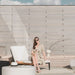 Woman Sitting At The Edge of a Francis Outdoor Lounger In Palisades Color With Black Base