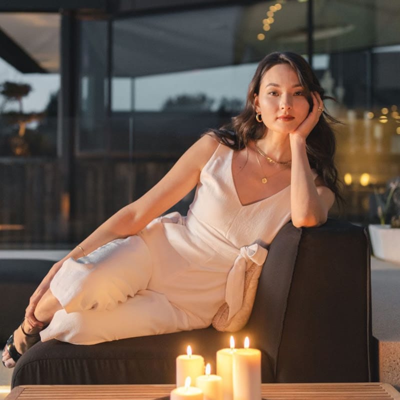 Francis Outdoor End Table With Candles On Top In front of a Woman Lounging