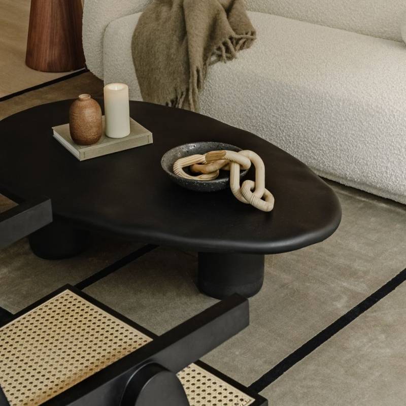 Close up View of The Kara Coffee Table With Black Concrete Surface With Candle and Other Decorations