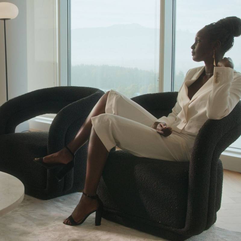 Woman Sitting on a Mia Lounge Chair in Caviar Fabric and Color