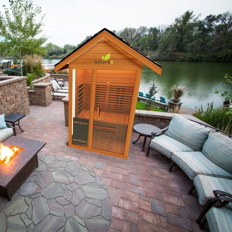 Medical Saunas 3-Person Nature 6 Ultra Full Spectrum Outdoor Dry Sauna In Backyard Next To a Couch And a Lake