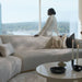 Woman Sitting With Her Back Facing The Romulus Nesting Coffee Table in White Travertine in a Living Room