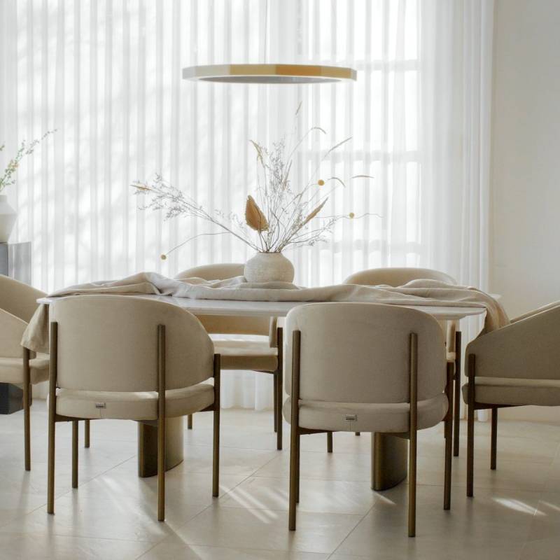 Several Solana Dining Chairs in Alesund Fabric and Antique Brushed Brass Base at a Dining Table