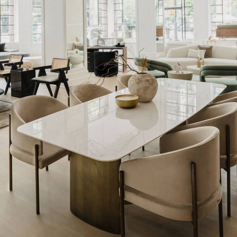 Six Solana Dining Chairs in Latte Fabric and Antique Brushed Brass Base at a Dining Table