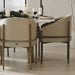 Close Up of Solana Dining Chairs in Latte Fabric and Antique Brushed Brass Base at a Dining Table