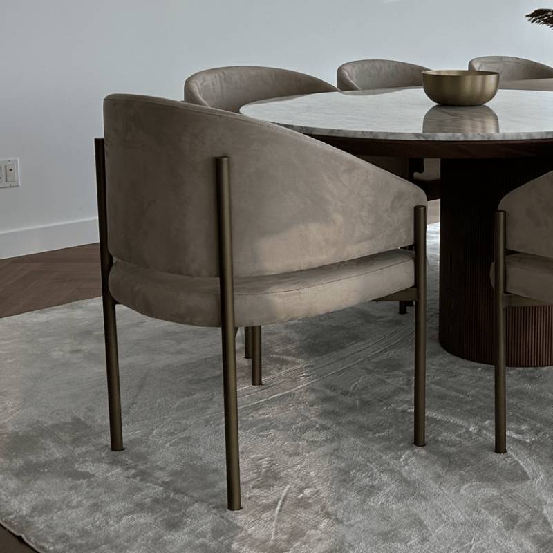 Several Solana Dining Chairs in Latte Fabric and Antique Brushed Brass Base at a Dining Table