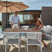 Couple Using a White Spencer Outdoor Dining Table With Linnea Outdoor Chairs