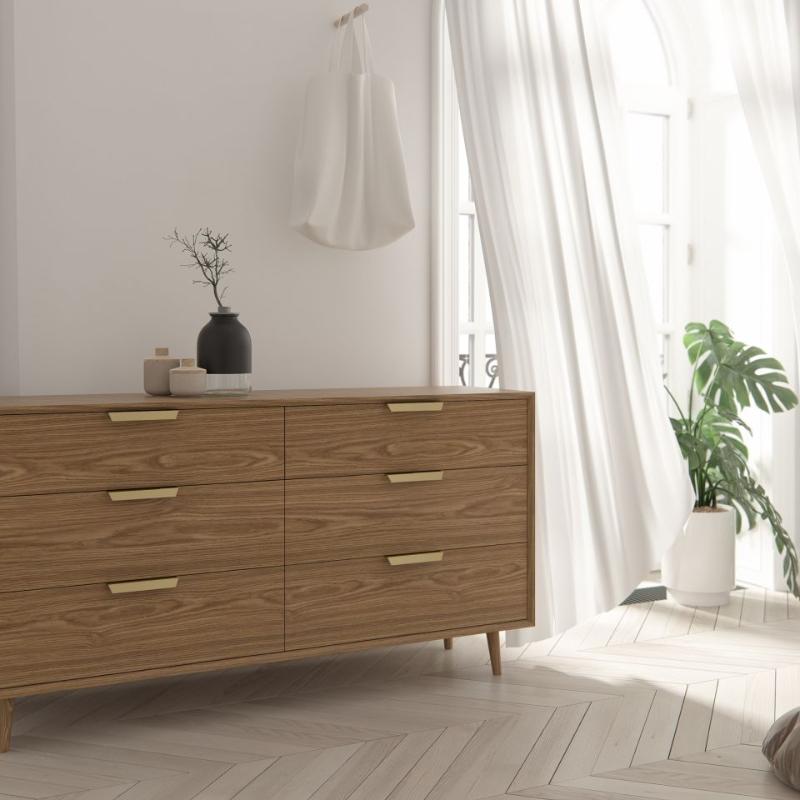 Front Facing View of The Asher Wide Dresser in an Ash Veneer Finish Against a Bedroom Wall Next to a Window