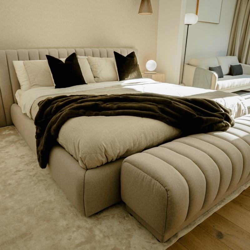 Angled View of The Berlin Bed With Pearl Fabric in a Bedroom With a Berlin Bench at The Base of The Bed