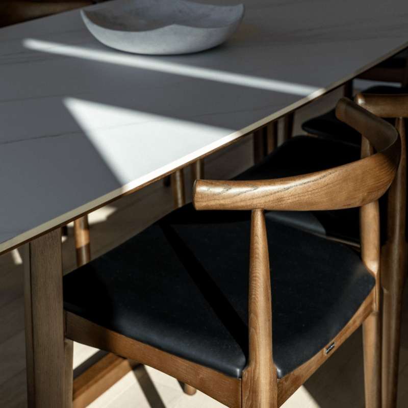 Close Up View of The Evelyn Dining Table in White Carrara Marble With a Dining Chair