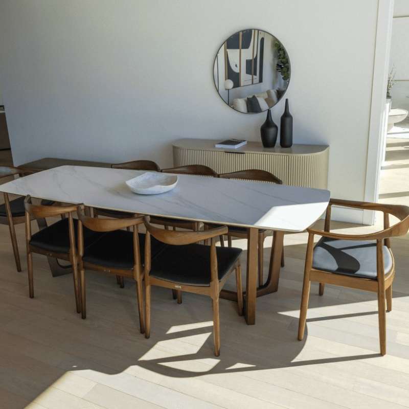 The Evelyn Dining Table in White Calacatta Ceramic in a Dining Area With Eight Chairs Surrounding 