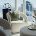 The Liza Pedestal in White Carrara Marble Behind a Chair Next to a Window