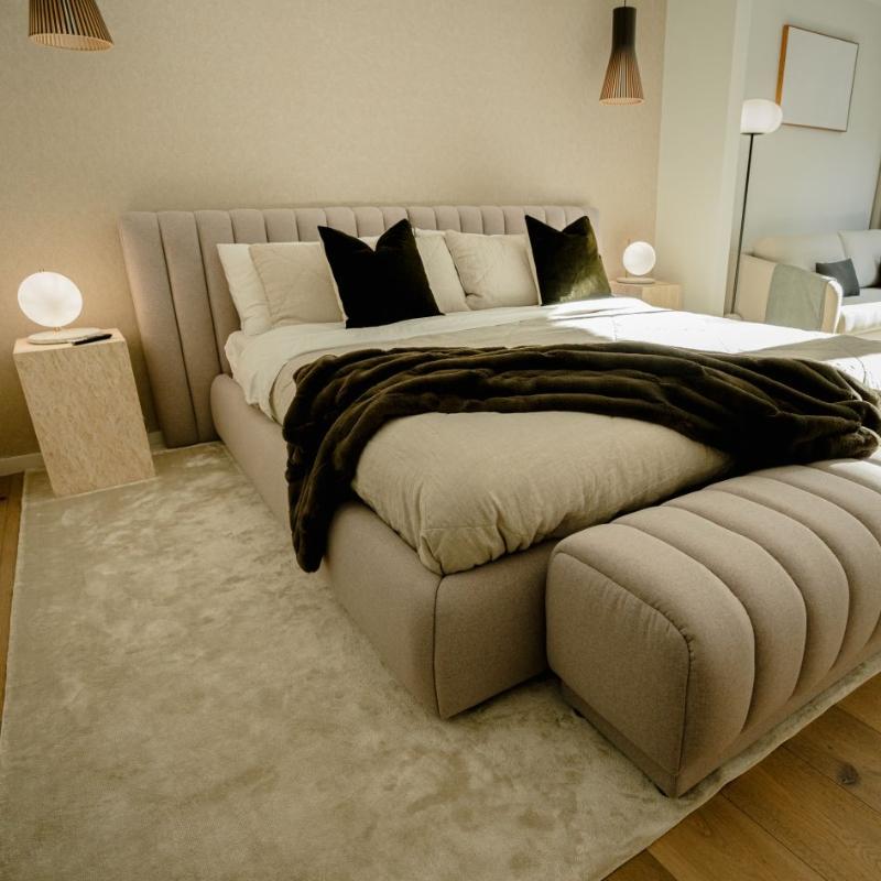 Two Liza Side Tables (Black Label) in White Travertine Next to a Bed