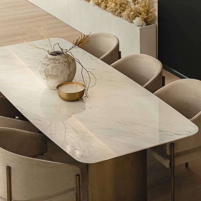 Angled Top View of The Solana Dining Table With a White Carrara Marble Surface and Antique Brushed Brass Base in a Dining Area