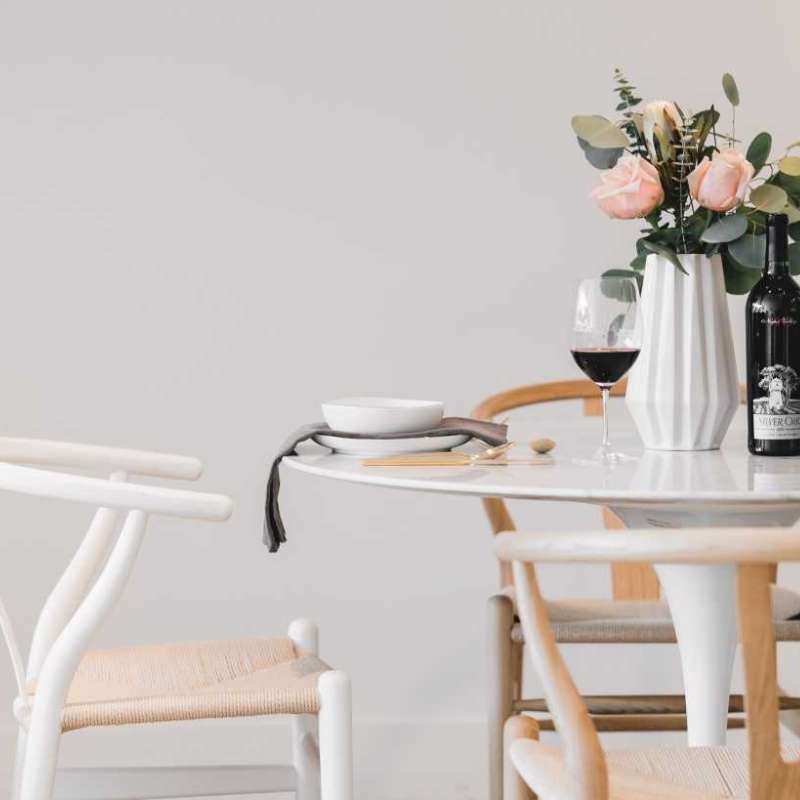 Close Up View of The Tulip Table Round With White Carrara Marble Surface and White Base With Table Setting