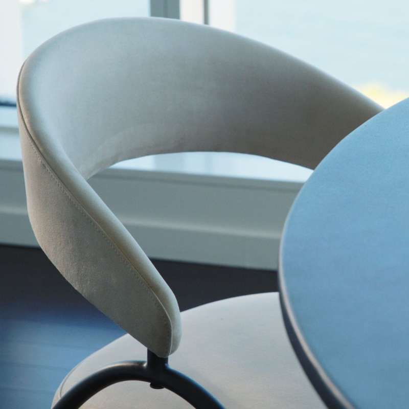 Close Up Side View of an Uma Dining Chair in Latte Fabric and Color at a Dining Table 